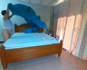 Nudist housekeeper Regina Noir makes the bedding in the bedroom. Naked maid. Naked housewife. c2